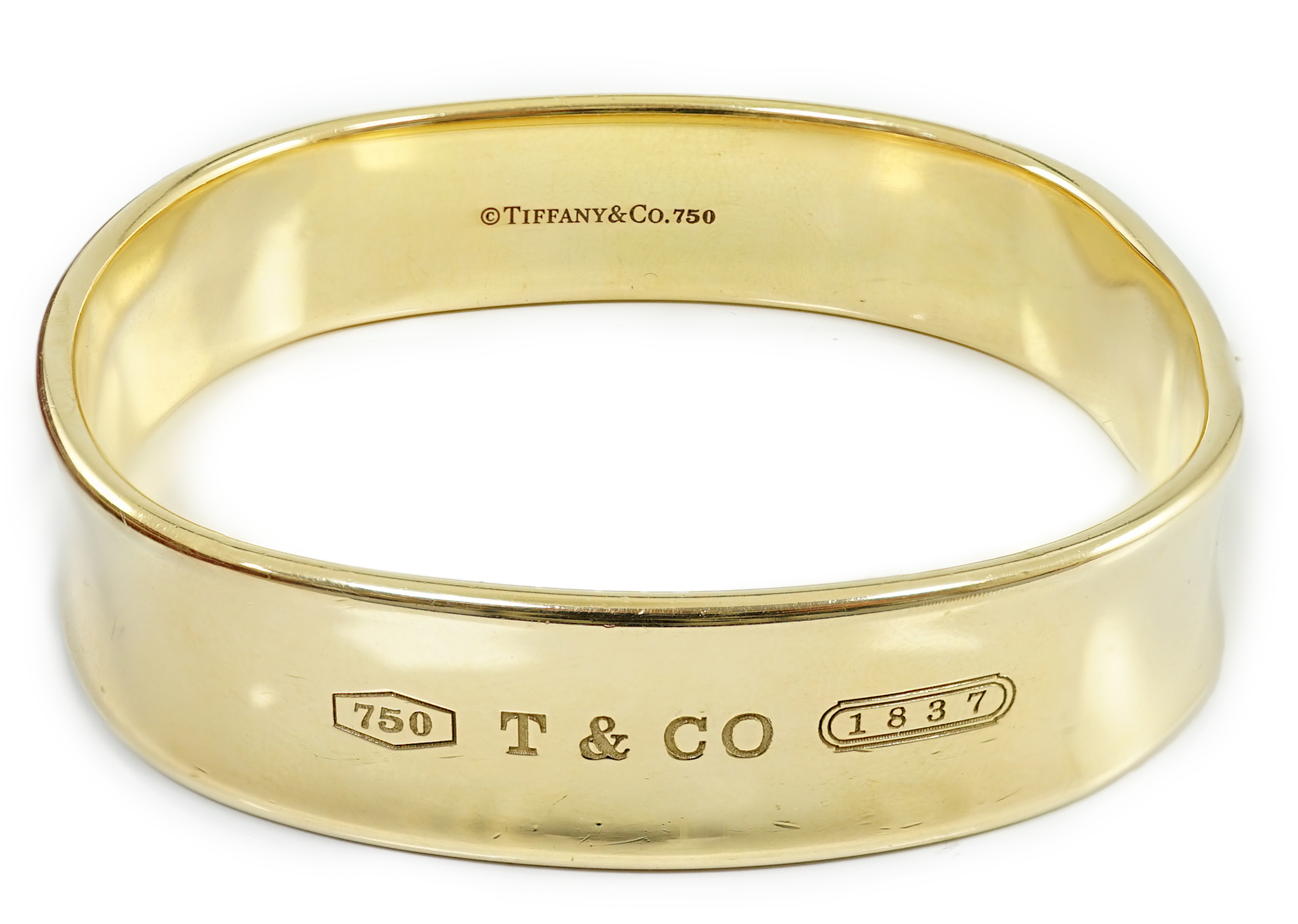 A modern heavy Tiffany & Co 18ct gold shaped bangle